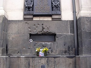 Plaque commémorative en l'honneur des membres de l'opération Anthropoid et de Jaroslav Švarc au-dessus des impacts de balle qui les avaient visés