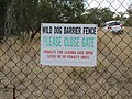 Dingo Barrier fence sign, near Bell, Queensland, Australia. Sign on gate for stock adjacent to cattle grid. 2018