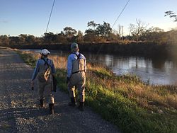 two people walking along river