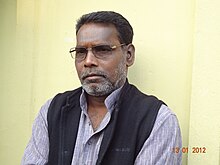 Tarai standing in front of a yellow wall