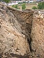 Vista desde el sur del foso de 6 m de profundidad excavado en la roca que protegía la parte este del castro.