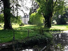 Photographie du château dissimulé dans son parc.