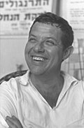 תצלום תקריב שחור-לבן של דן בן אמוץ מחייך, משנת 1961.