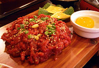 Yukhoe is a variety of hoe (raw dishes in Korean cuisine), which are usually made from raw ground beef seasoned with various spices or sauces.