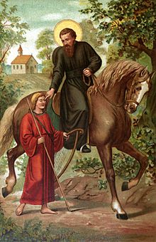 A man with a black tunic and a halo reaches down astride a horse to touch the eyes of a barefoot man in red robes holding a harp and a walking stick