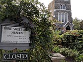 The foreground sign is at the entrance to the Home Sweet Home museum; the building in background is St. Luke's Church