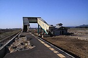 東北地方太平洋沖地震による津波で被災した後の坂元駅。ホームはえぐれ、跨線橋とコンクリート造の公衆トイレ以外は流失した（2011年5月）