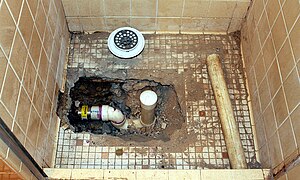 Shower repair showing drain piping with trap