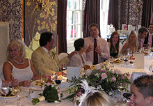 Entertainment at an English wedding breakfast. The organisers have hired two opera singers to sing arias during the meal, for the entertainment of the guests. The mother of the groom is being serenaded.