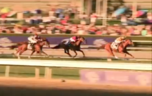 Three mounted horses race at Santa Anita Park