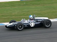 Photograhipe d'une Cooper T53 noire, vue de profil, sur une piste.