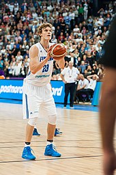 Un joueur de basket-ball au lancer-franc devant une foule nombreuse.