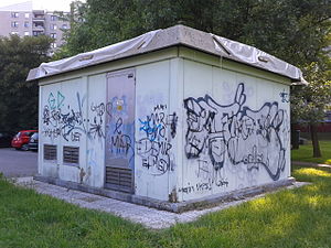 A small power transformer building covered in graffiti.