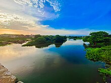 A slow moving river at sunset reflecting the sky