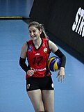 woman in sports gear with a volleyball under her arm