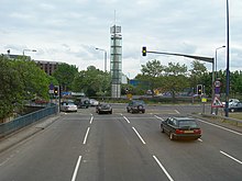 Four lanes of traffic approach a set of traffic lights.