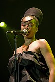 An Afro-American woman singing through a microphone.