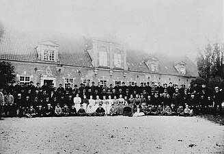 Arbetare och tjänstefolk framför norra flygeln omkring 1900.