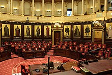 Vue de l'hémicycle du sénat belge depuis la tribune du président. Dans le fond de l'hémicycle, on voit neuf des quinze peintures historiques de Gallait qui décorent le pourtour du sénat belge. Les quinze peintures furent réalisées de 1872 à 1877. Sur la vue, on voit de gauche à droite: Philippe d'Alsace, Jean II duc de Brabant, Guillaume le Bon, Philippe le Noble, Philippe le Bon, Charles Quint, l'archiduchesse Isabelle, l'archiduc Albert, l'impératrice Marie-Thérèse.