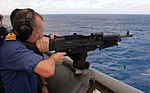 Der britische Commodore Fitzsimmons feuert bei einem Besuch auf der USS Nashville ein M240 Maschinengewehr ab, Januar 2009