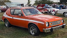 Une voiture orange, vue de trois-quarts avant.