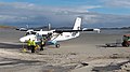 Twin Otter at Barra airport, ground crew preparing for takeoff