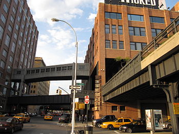 The High Line between 14th and 15th streets where the tracks run through the second floor of the Chelsea Market building, with a side track and pedestrian bridge