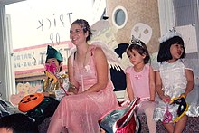 A woman dressed as a fairy surrounded by children