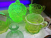 A collection of green-yellow glass jars fluorescing under UV light