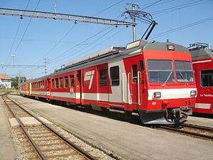 Red-and-white train next to an island platform