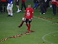 A footballer holding a silver trophy