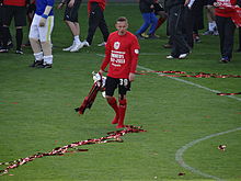 A footballer holding a trophy