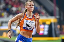 Photo of Femke Bol in orange and blue clothing while sprinting