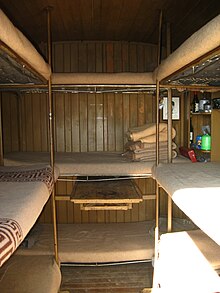 interior of a mountain bivouac hut showing bunk beds
