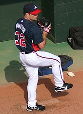 An overhead view of a man with one leg lifted preparing to throw a ball