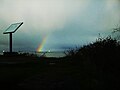 An interpretive sign with rainbow in the background