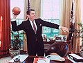 President Ronald Reagan with a football in the Oval Office