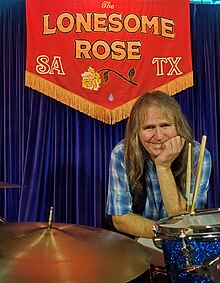 Photo of the drummer, Sam Henry, sitting at his drum set before a performance.