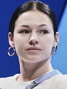 Kateryna Pavlenko smiling at the camera. She is wearing a black sleeveless shirt and a necklace.