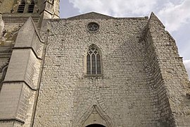 Vue de la façade laissant deviner l’ornementation du portail et les dix niches le surmontant, martelées lors des guerres de Religion