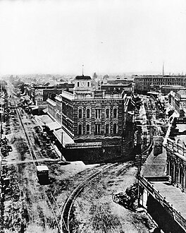 Temple Block c.1885. Courthouse clocktower visible immediately behind Temple Block. Main St. (l), Spring St. (r)