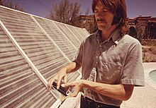 Photo of Meinel's son Walter demonstrates a solar heating panel being used to heat the swimming pool of the family home