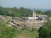 Photographie d'une structure en ruines de Palenque, au milieu de la jungle.