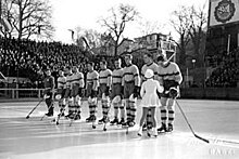 Black and white photo of hockey team standing in a row on the ice