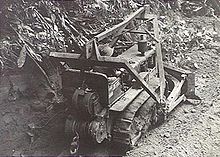 A bulldozer clears a path through the jungle