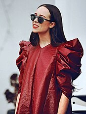 A woman wearing a burgundy dress and sunglasses.