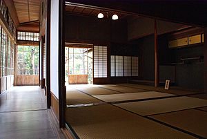 View along wood-floored engawa towards a corner showing shoji edge-on and, on the far side of the corner, from the inside, with light shining through.