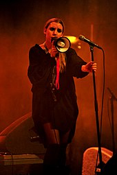 Lykke Li during a concert, performing in red lightning.