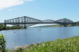 El puente de Quebec tiene en el vano central una viga en el medio apoyada en dos ménsulas en voladizo que se extienden por encima y por debajo de la carretera.