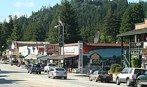 Looking north from Highway 9 at the Boulder Creek Hardware building and the 70-foot-long (21 m) painted mural by John Ton, depicting two phases of the community's history